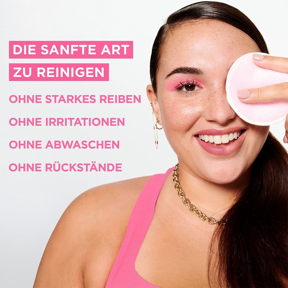Lächelnde Frau wischt mit einem Reinigungsbad über ihr linkes Auge